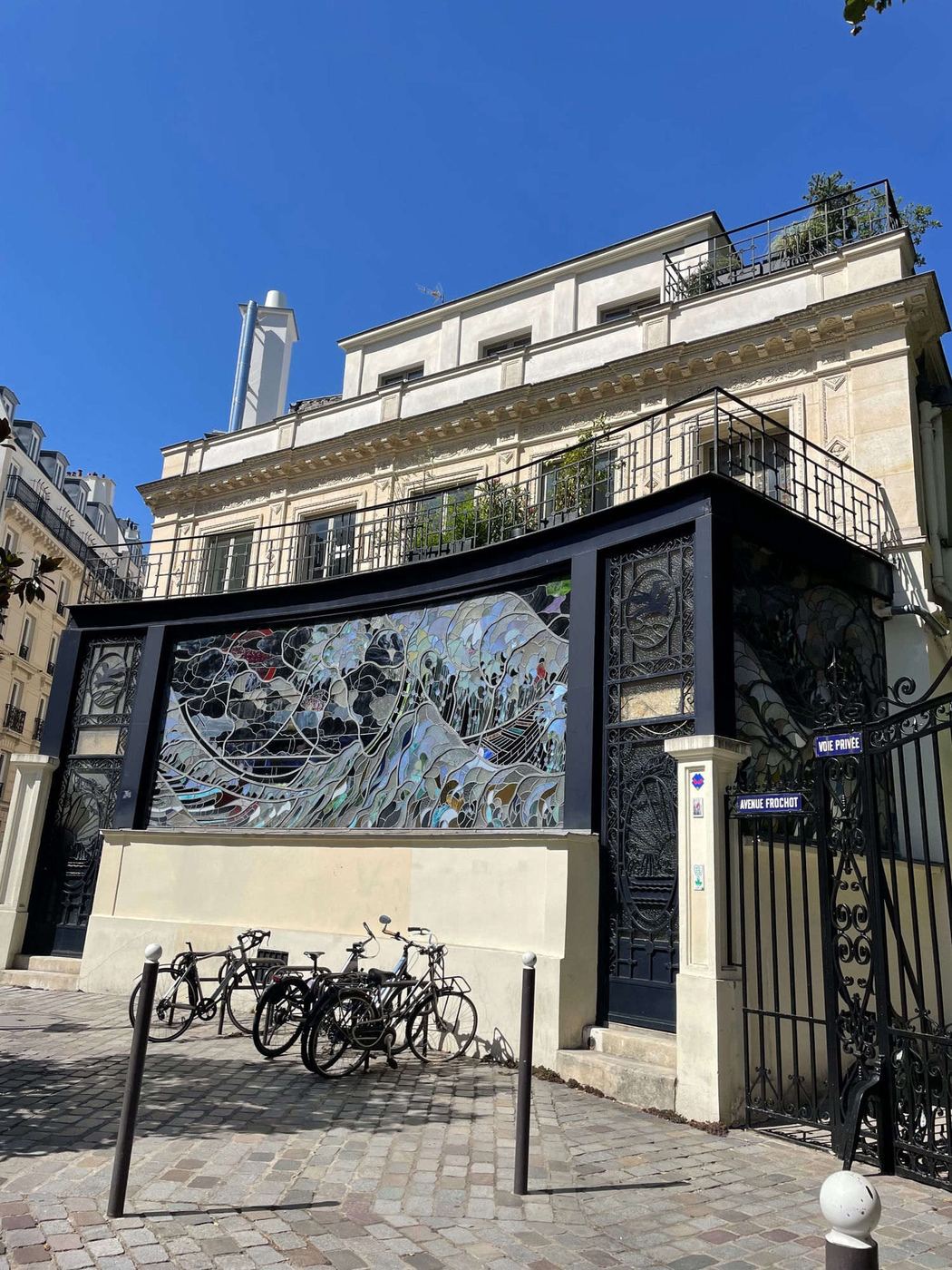 A grand carriage gate framed by a climbing vine in Paris